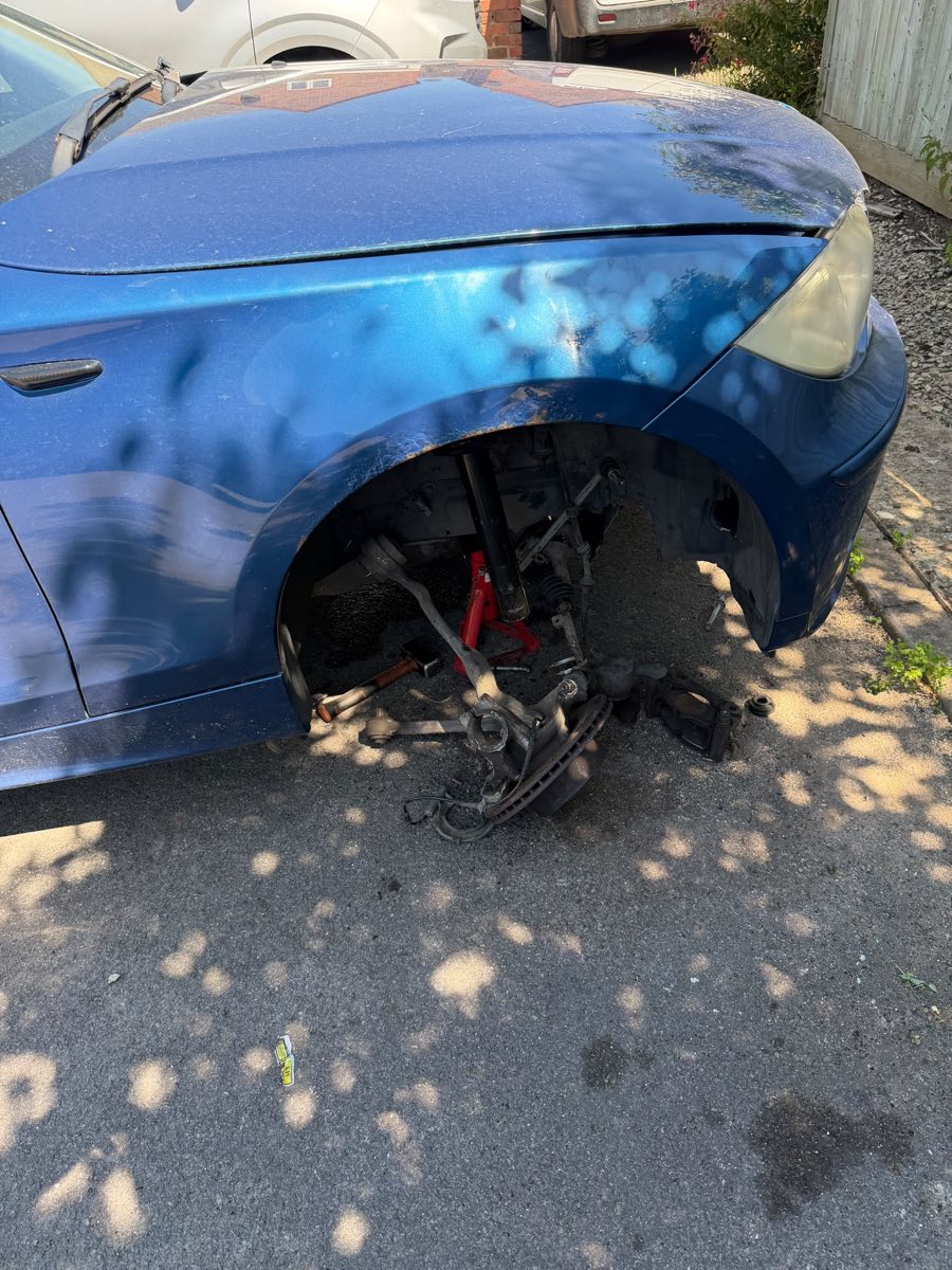 Front suspension and hub work on a blue BMW